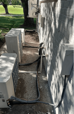 Air conditioning units outside on concrete slab.