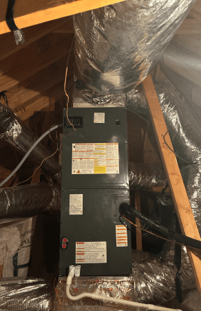 Air conditioning unit in attic with ducts.